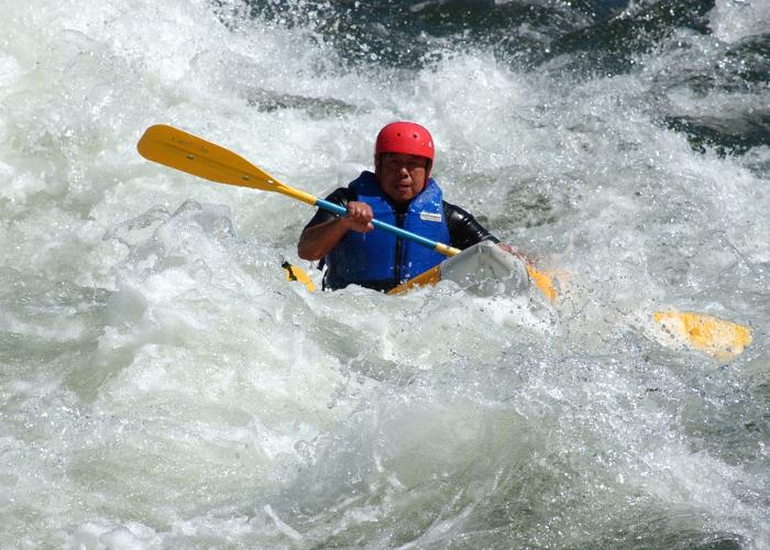Kayaker in the middle of whitewater paddleing the rapids