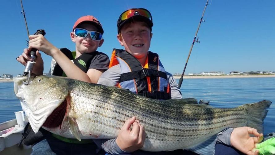 Daniel and Jon holding a monster stripe bass on the east coast