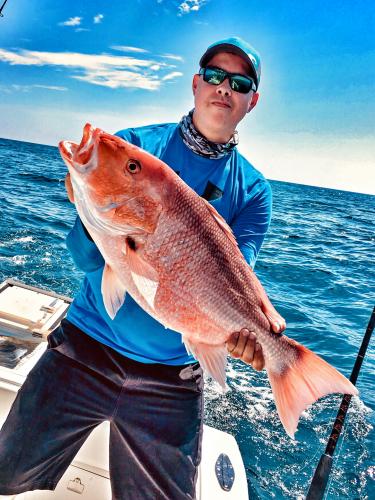 Angler holding up a large saltwater Red Snapper