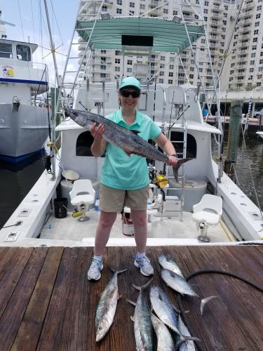 Proud lady angler holding up one of her larger tuna catches for the day