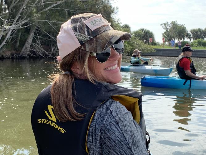 Jessie is looking back at the camera as she is Kayaking in Florida