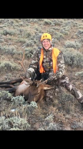 Hunter holding up the antlers of a bull elk