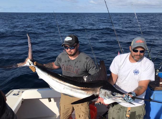 Two anglers holding a Swordfish
