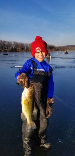 Young ice angler with large bass
