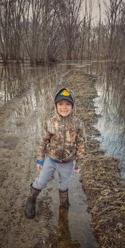 Young boy hiking in a flooded area