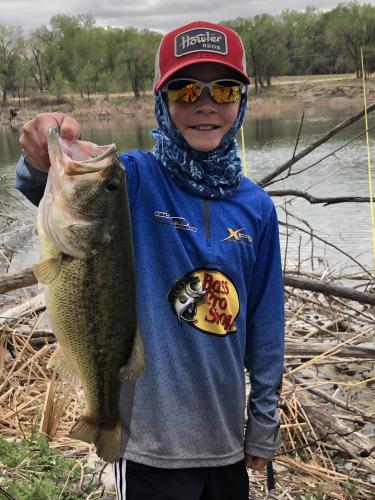 Boy angler holding largemouth bass