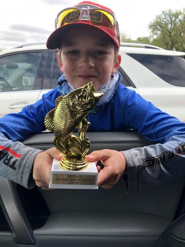 Young boy with hisfishing tournament trophy