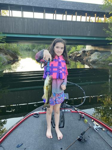 Young girl holding a river bass