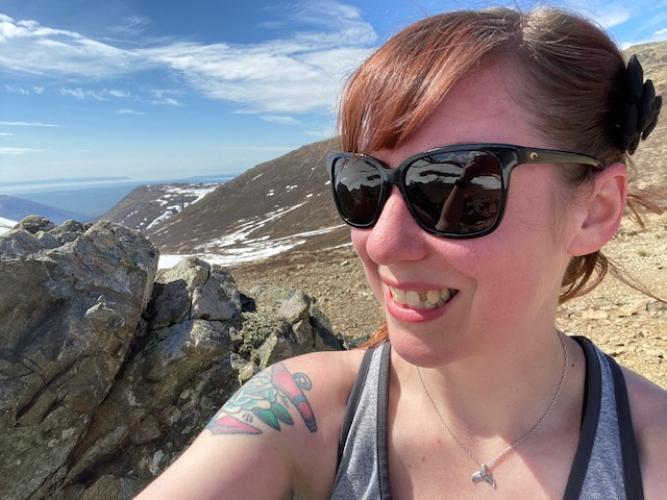 Girl backpacker on mountain ridge