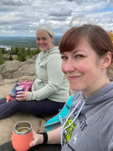 2 people sitting on a rock ridge