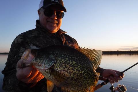 A Fisherman with a Spinning Rod To Catch Fish. Sunglasses and