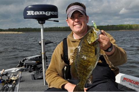 Angler in boat holding smallmouth bass