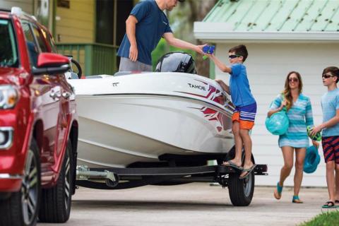 Family of four loading a boat with boating gear for a trip to the lake
