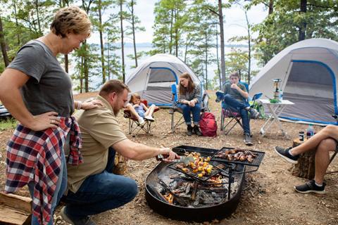 Family at camp cooking over a campfire