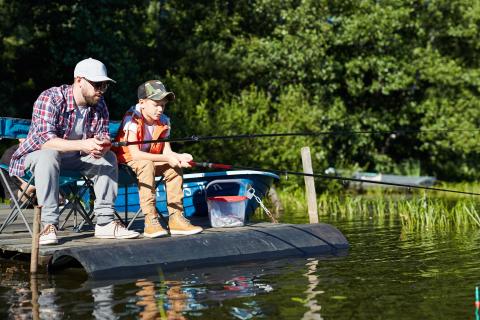 Father & son fishing from a boat dock by Father & son fishing from a boat dock...