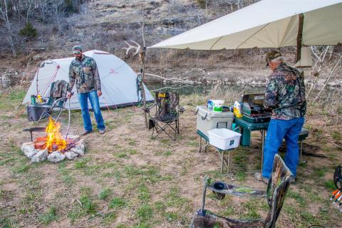 Two hunters cooking at camp