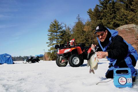 Ice angler on a frozen lake fishing crappie