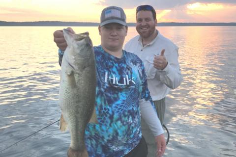 Two bass anglers on Kentucky lake, one with a bass