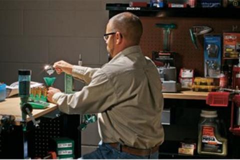 Man at table reloading ammo