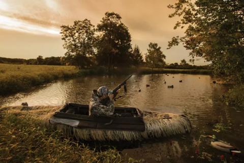 Waterfowl huntr in blind boat