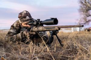 Coyote hunter in camo with a high power scope