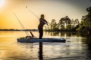 angler fishing from kayak at sunrise