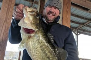 Bass angler holding up a largemouth bass caught in Guntersville lake