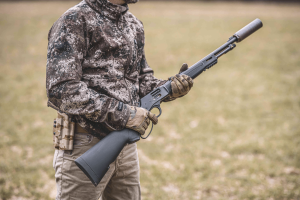 Hunter holding a silenced lever action rifle.