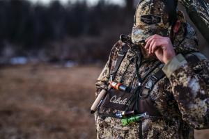 hunter in camouflage tipping his hat down