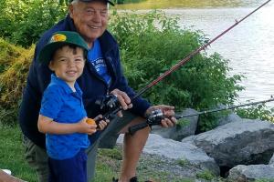 Young angler fishing with grandfather