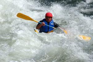 Kayaker in the middle of whitewater paddleing the rapids