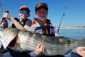 Daniel and Jon holding a monster stripe bass on the east coast