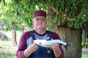 Angler hold a White Catfish under a shade tree