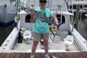 Proud lady angler holding up one of her larger tuna catches for the day