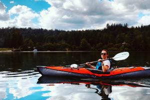 Woman kayaking on a calm lake where the water is like glass