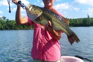 Lady angler holding up a Lunker Bass