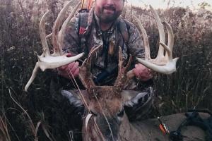 Deer hunter holding up a 19 point buck he shot with a bow