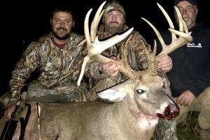 Two hunters with a nice buck durking bow hunting season
