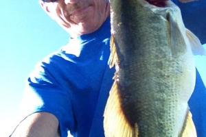 Angler holding up a heavy largemouth bass 