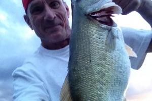 Angler shooting selfie with a nice largemouth bass