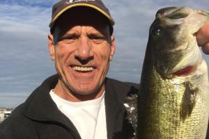 Happy Angler holding up a largemouth bass