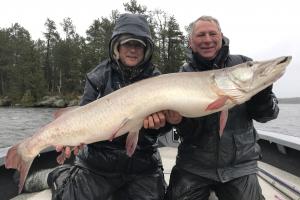 Two anglers holding up a giant fall muskie