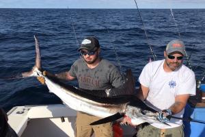 Two anglers holding a Swordfish