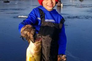 Young ice angler with large bass