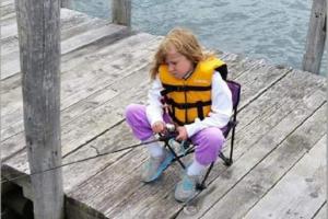 Young girl sitting on a dock fishing