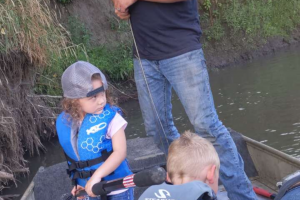 Father and two children fishing on the river