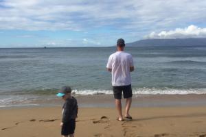 Young child & father on the sandy beach