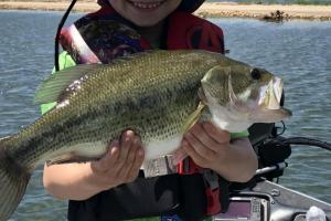 Young angler holding up a bass