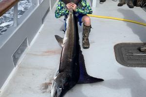 Young boy angler posing with his blue marlin