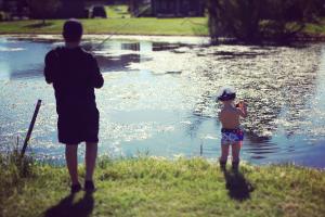 Small boy and angler fishing